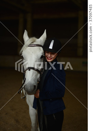 Smiling woman stands with white horse . 37097485