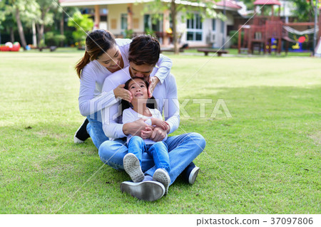 Happy male and female playing with children outside 37097806