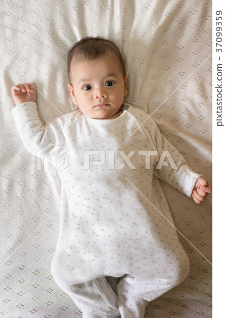 Portrait of a newborn Asian baby on the bed. Portrait of a newborn Asian baby on the bed. 37099359