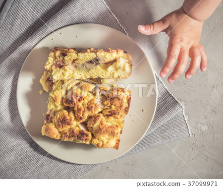 Kid is trying to pick up a piece of pie Kid is trying to pick up a piece of pie 37099971