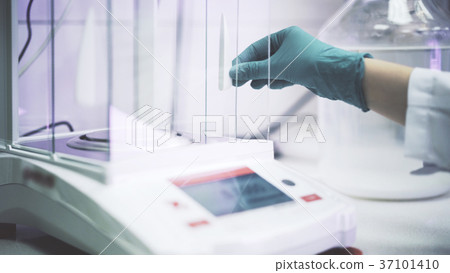 Scientist s hand in a green glove is putting Scientist s hand in a green glove is putting 37101410