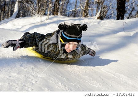 Little boy riding with hills on sleds Little boy riding with hills on sleds 37102438