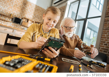 Joyful nice boy concentrating on his activity Joyful nice boy concentrating on his activity 37103330
