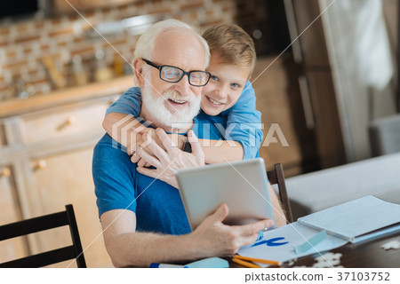 Happy cute boy hugging his grandfather Happy cute boy hugging his grandfather 37103752