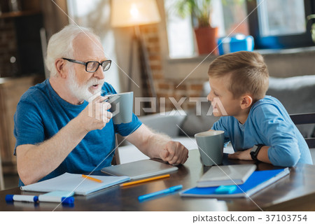 Delighted nice grandfather and grandson having tea Delighted nice grandfather and grandson having tea 37103754