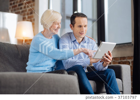 Lively senior woman and her son doing online Lively senior woman and her son doing online 37103797