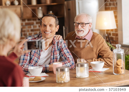 Elderly woman taking photo of her family at 37103949