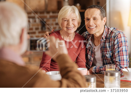 Elderly man taking photo of his family at 37103950