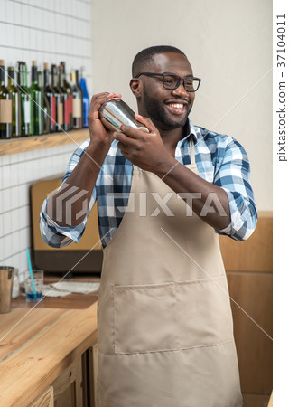 Excited skilled barman smiling while making a nice 37104011