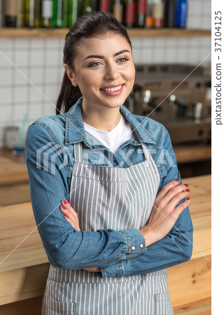Cute young waitress standing with her arms crossed 37104125