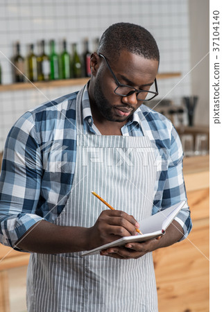 Attentive worker of a cafe standing and making 37104140