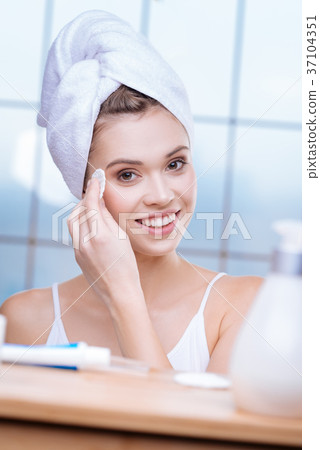 Beautiful woman in towel turban applying tonic Beautiful woman in towel turban applying tonic 37104351