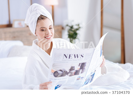 Pleasant woman in bathrobe reading news 37104370