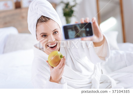 Upbeat woman taking selfie with apple after shower 37104385