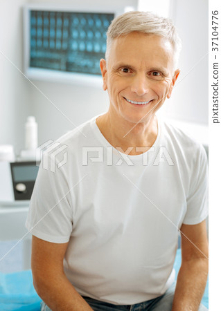 Happy delighted man sitting in the doctors office Happy delighted man sitting in the doctors office 37104776