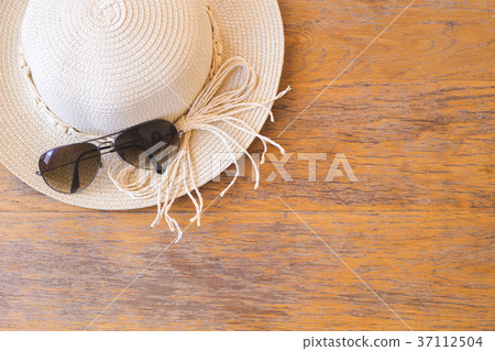 Straw hat with sun glasses on wooden background. 37112504