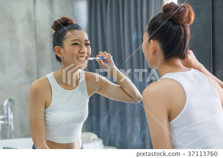 Girl is blushing her teeth Girl is blushing her teeth 37113760