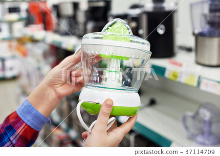 Electric juicer in hands of buyer at store Electric juicer in hands of buyer at store 37114709