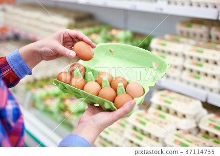 In hands of woman packing eggs in supermarket In hands of woman packing eggs in supermarket 37114735
