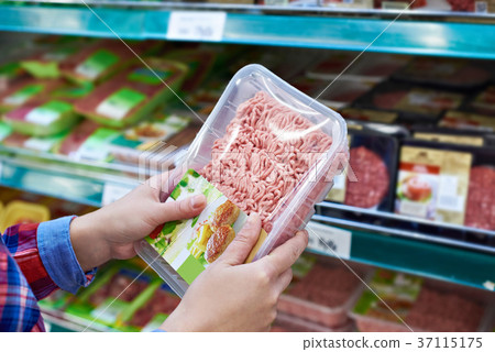 Buyer chooses minced meat in store 37115175