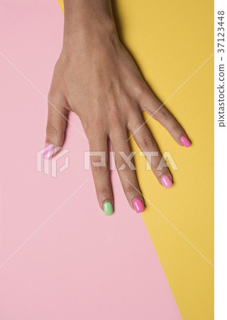 woman hand with her nails painted pink and green woman hand with her nails painted pink and green 37123448
