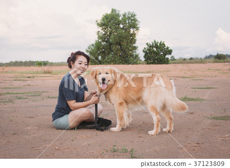 woman with her golden retriever dog playing woman with her golden retriever dog playing 37123809