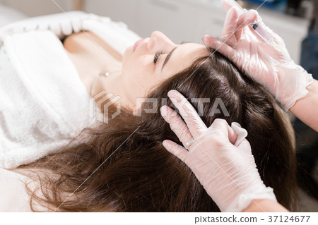 Handsome woman receives an injection in the head 37124677