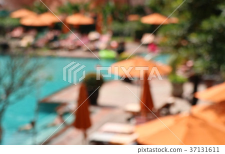 blurred swimming pool with umbrellas 37131611
