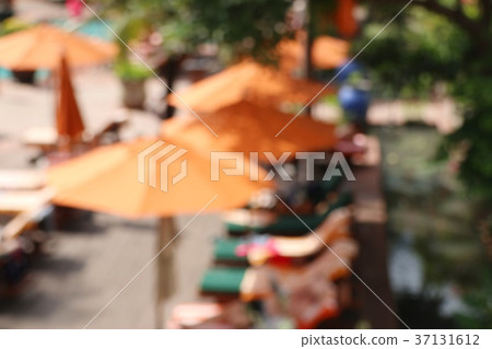 blurred swimming pool with umbrellas 37131612
