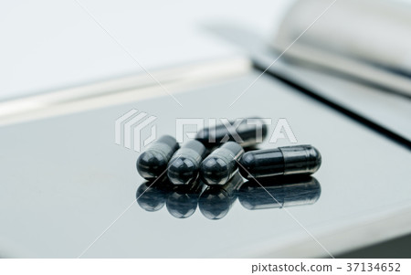Activated charcoal capsule on drug tray Activated charcoal capsule on drug tray 37134652