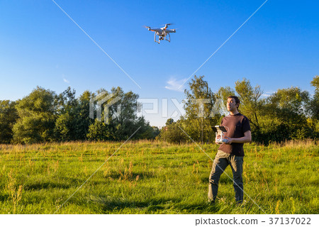 Man operating a drone quad copter 37137022
