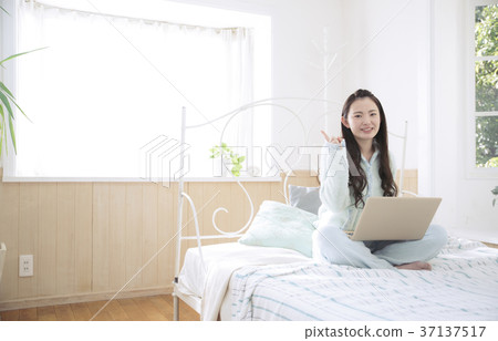 使用個人計算機的女孩在床上 37137517