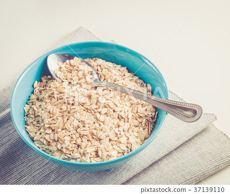 Oat flakes in blue bowl ready to cook Oat flakes in blue bowl ready to cook 37139110