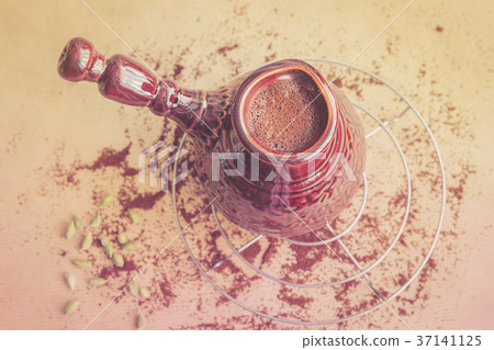 Fresh turkish coffee in brown ceramic cezve 37141125