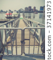 Blurred image of a wooden dock leading to boats 37141973