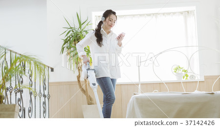 Girl cleaning while listening to music 37142426