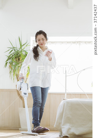 Girl cleaning while listening to music 37142437