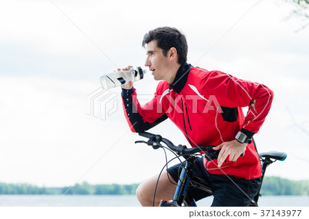 Sport man on mountain bike drinking water on rest Sport man on mountain bike drinking water on rest 37143977