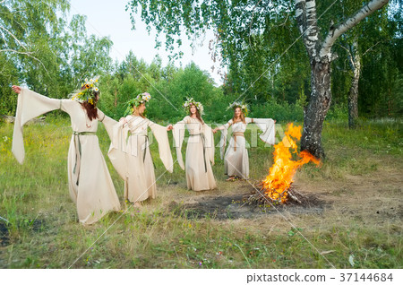 Beautiful women with flower wreath near bonfire Beautiful women with flower wreath near bonfire 37144684