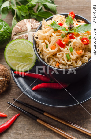 Instant noodles in black bowl on wooden background 37144992