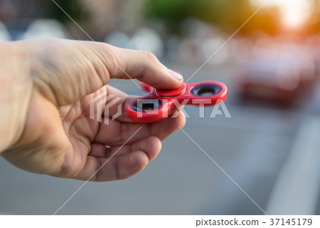 Man playing with fidget spinner stress toy 37145179