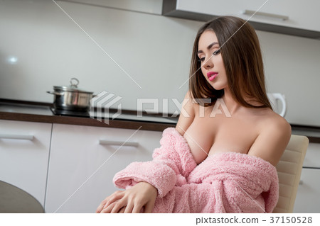 Sexy busty girl posing in pink bathrobe on kitchen - Stock Photo 37150528 