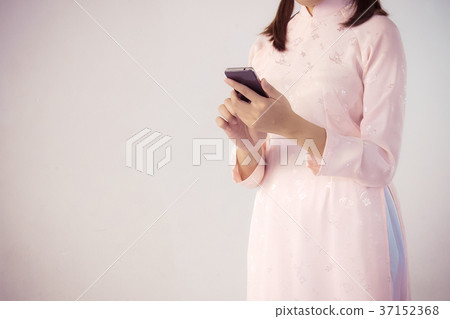woman in pink dress holding smartphone 37152368
