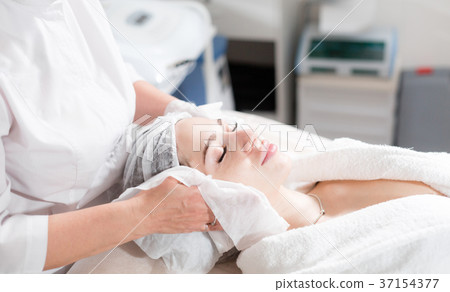 Wipe with sterile napkin face. Young pretty woman 37154377