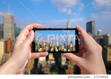Female take picture of Manhattan on mobile phone Female take picture of Manhattan on mobile phone 37159403