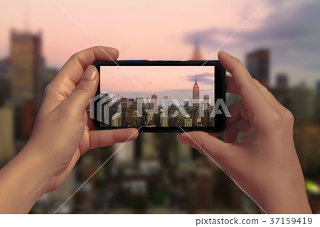 Female take picture of Manhattan on mobile phone Female take picture of Manhattan on mobile phone 37159419