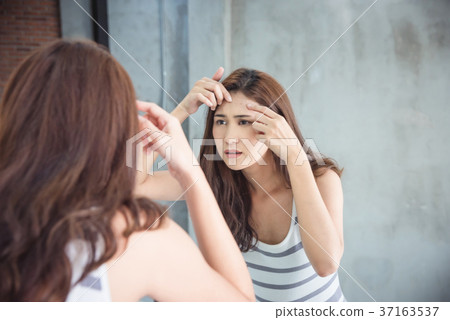 Woman squeeze her pimple in bathroom Woman squeeze her pimple in bathroom 37163537
