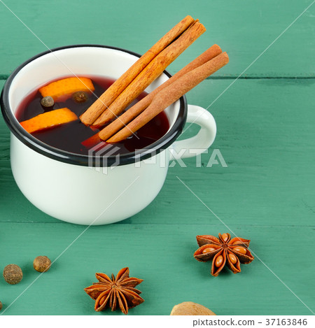 Hot red mulled wine on wooden background Hot red mulled wine on wooden background 37163846