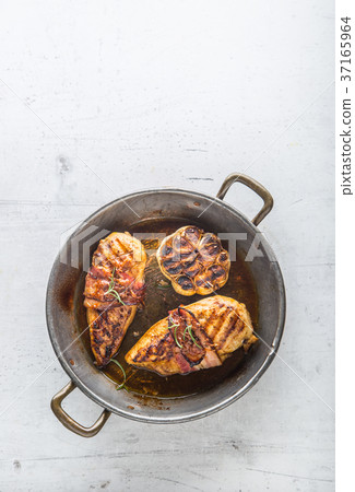 Roasted chicken breast with bacon and garlic. 37165964