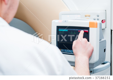 Doctor adjusts electrocardiograph Doctor adjusts electrocardiograph 37166151